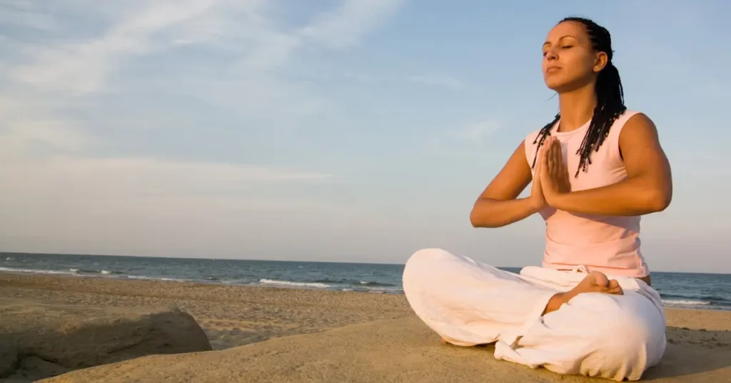 o que é mindfulness - woman meditating indoors natural light