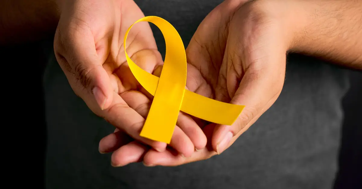 Pessoa meditando com laço amarelo. Mídia quebra o tabu e promove o cuidado da saúde mental durante Setembro Amarelo.